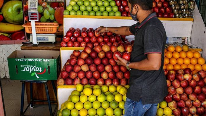 A fruit vendor arranges produce at his store in Bengaluru, in June, 2021 | Dhiraj Singh | Bloomberg