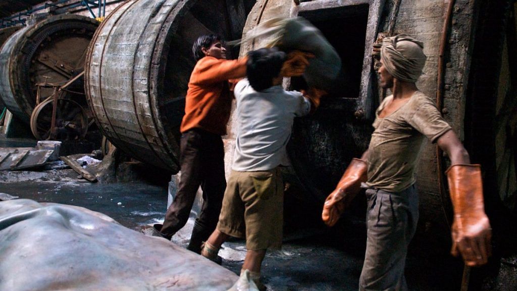 Workers at one of Kanpur, Uttar Pradesh's four hundred tanneries, the city's primary industry, load hides into well-used tumblers. Treating leather in this manner is a multi-step process requiring chemicals such as chronium and copious amounts of water.