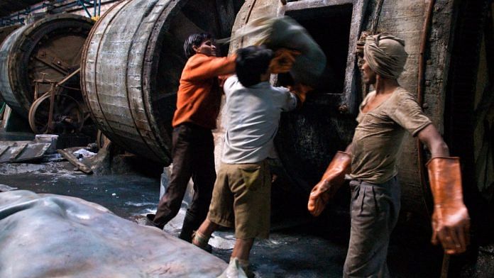Workers at one of Kanpur, Uttar Pradesh's four hundred tanneries, the city's primary industry, load hides into well-used tumblers. Treating leather in this manner is a multi-step process requiring chemicals such as chronium and copious amounts of water.