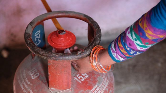A woman connects an LPG cylinder to a stove at her home in Greater Noida | Photo: T. Narayan | Bloomberg