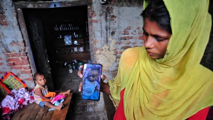 Nazrana shows the only photo she has of her infant son Rehan, who was allegedly killed by her husband earlier this week. Her daughter Rehnuma is seen in the background | Suraj Singh Bisht | ThePrint