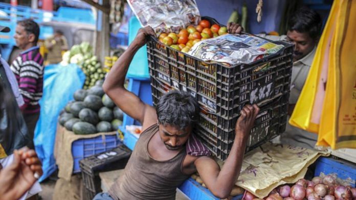 A worker unloads crates of tomatoes from a truck at a vegetable store in Tamil Nadu | Representational image | Dhiraj Singh | Bloomberg