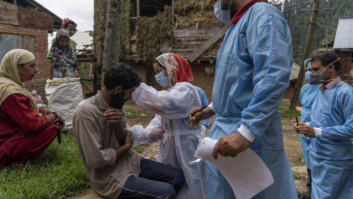 A member of a 'door-to-door' Covid vaccination team inoculates a resident in the Budgam district of Jammu and Kashmir, on 31 July 2021 | Sumit Dayal | Bloomberg