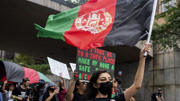 A demonstrator holds an Afghan flag while marching during a 'Save Afghan Lives' rally near the UN headquarters in New York, on 28 August 202