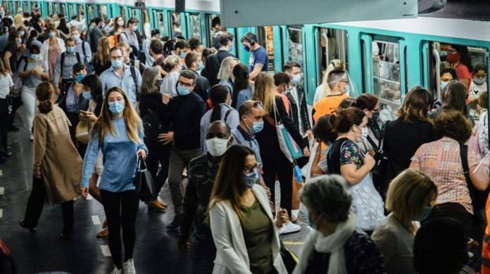 File photo of commuters wearing protective face masks while boarding and exiting a train at Saint-Lazare metro railway station in Paris, France. | Photographer: Cyril Marcilhacy | Bloomberg