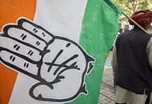 A Congress supporter carries its flag outside the party's headquarters in New Delhi | File photo | Photographer: T. Narayan | Bloomberg