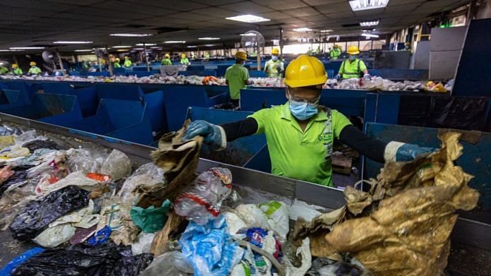 Workers sort solid waste material in the material recovery facility at the Bee'ah waste management complex in Sharjah, United Arab Emirates | Bloomberg