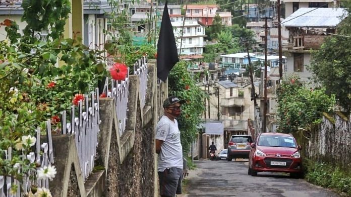 Grainui F.G. Diengdoh, son of ex-militant Cheristerfield Thangkhiew, stands outside his house in Shillong with a black flag in protest against the raid in which his father was encountered. | Photo: Praveen Jain/ThePrint