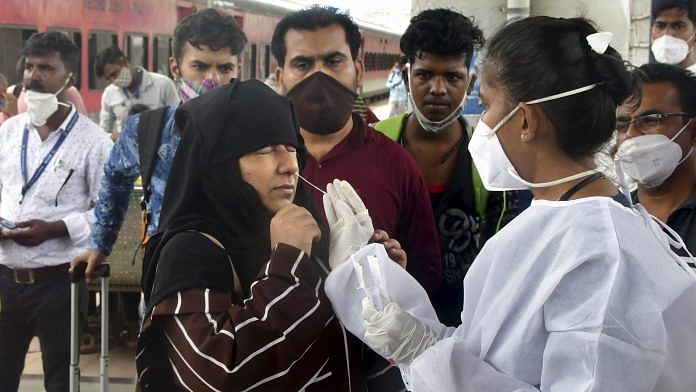A BMC health worker collects swab sample of a passenger for COVID-19 test, at Dadar station in Mumbai on 30 July, 2021 | PTI
