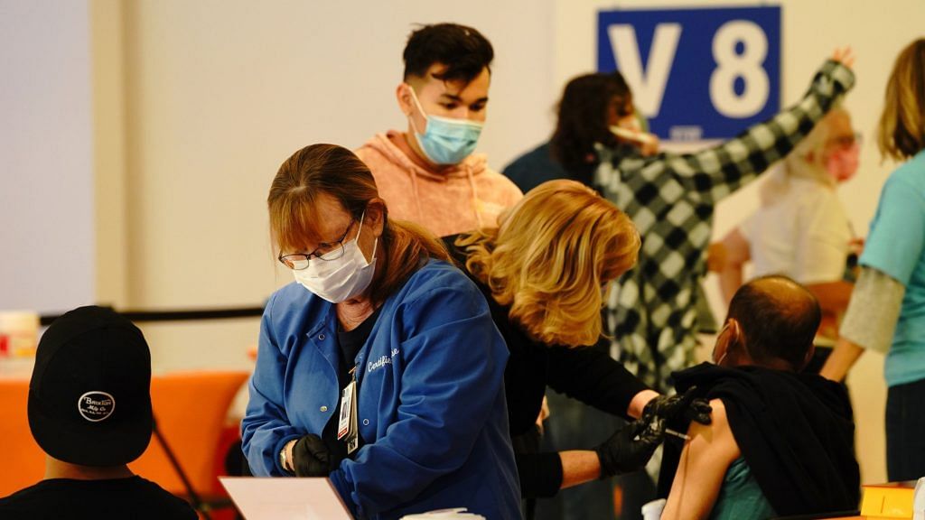 Healthcare workers administer Pfizer vaccines at a mass vaccination super site inside a mall in California on 11 February 2021