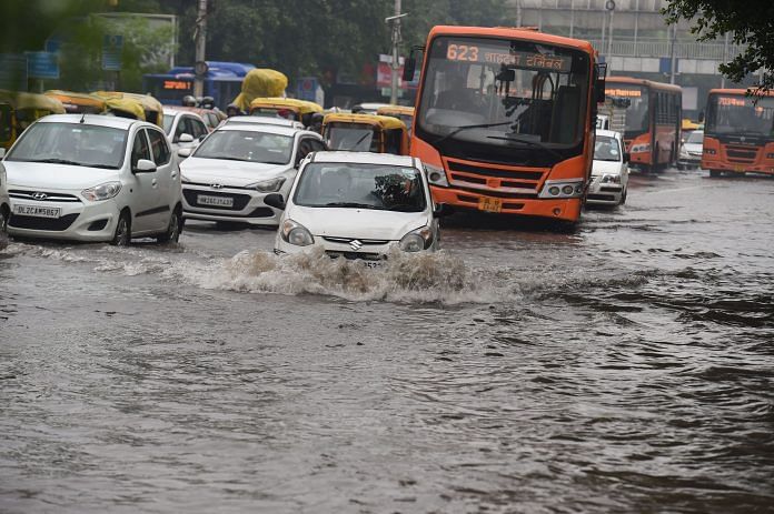 Commuters wade through a waterlogged area following heavy rains in New Delhi on 11 September 2021. | Atul Yadav | PTI