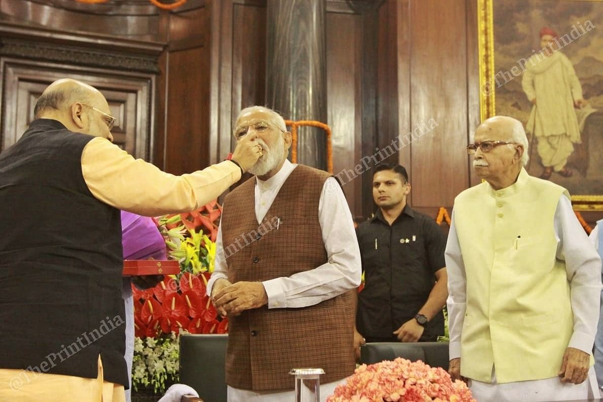 BJP president Amit Shah feeds sweets to PM Modi at the meeting on 25 May 2019 | Photo: Praveen Jain | ThePrint