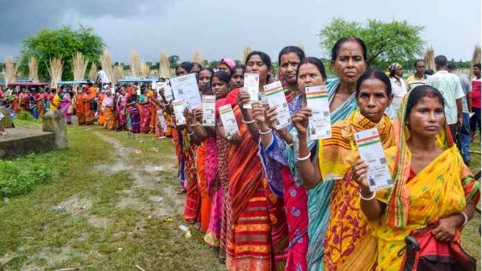 Beneficiaries show their Aadhaar Card as they wait in a queue to receive Covid-19 vaccine dose, at a government hospital in Nadia, West Bengal on 8 September 2021 | PTI