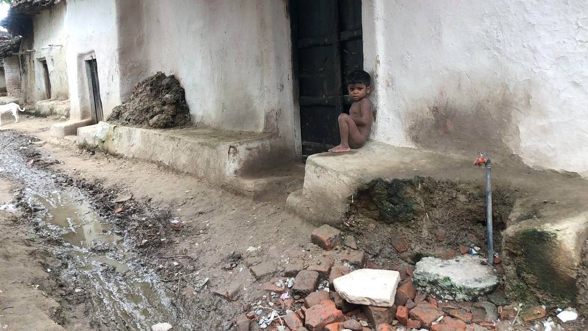 A broken-down lane in Adhawan village in Banda district's Baberu block. The tap, installed under the Central government's 'Har Ghar Nal Se Jal' scheme, looks as forlorn as the toddler sitting alone outside the house.