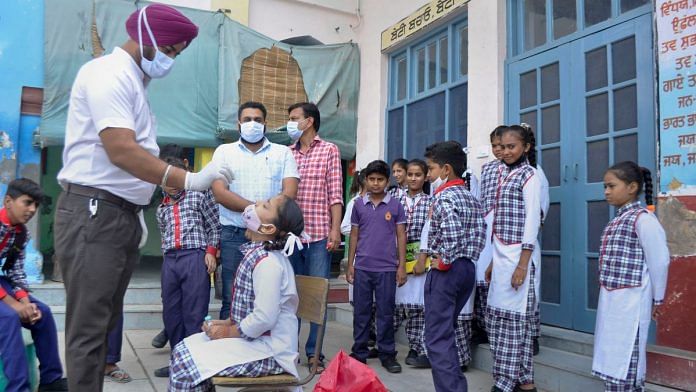 A health worker collects swab samples from a school student for Covid-19 testing at a government school in Patiala, on 14 September 2021 | PTI