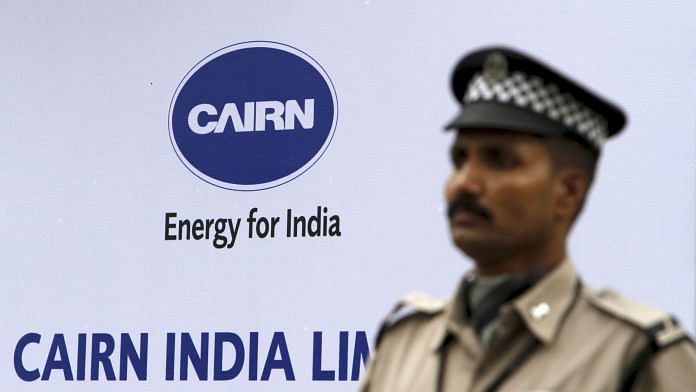 A security guard stands in front of a Cairn India logo in Mumbai | Photo: Adeel Halim | Bloomberg