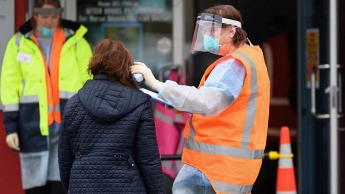 Representational image| File photo of a staff member wearing personal protective equipment check the temperature of patients in front of a medical centre in New Zealand | Photo by Kai Schwoerer/Getty Images | Bloomberg