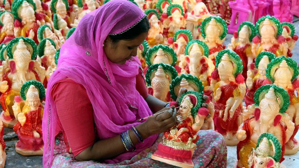 An artisan gives a finishing touch to idols of Goddess Laxmi and Lord Ganesha ahead of Diwali last year | Representational photo | ANI