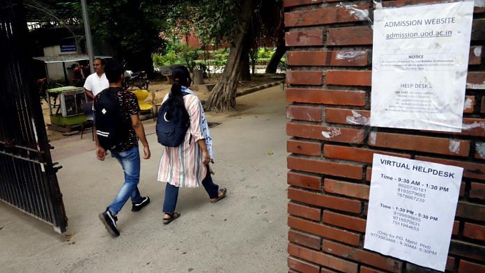 Students walk past a notice put on the DU art faculty's wall regarding online admission after the university announced its first cut-off list on 1 October 2021 | Representational image | ANI