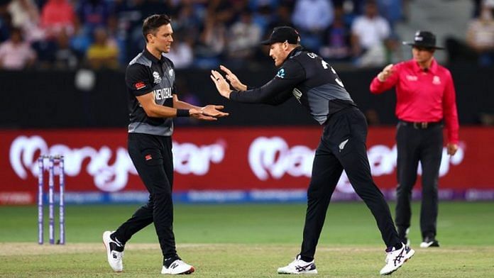 New Zealand fast bowler Trent Boult (left) celebrates a wicket with teammate Martin Guptill in their ICC Men's Twenty20 World Cup match against India in Dubai Sunday | Photo: Twitter | @BLACKCAPS