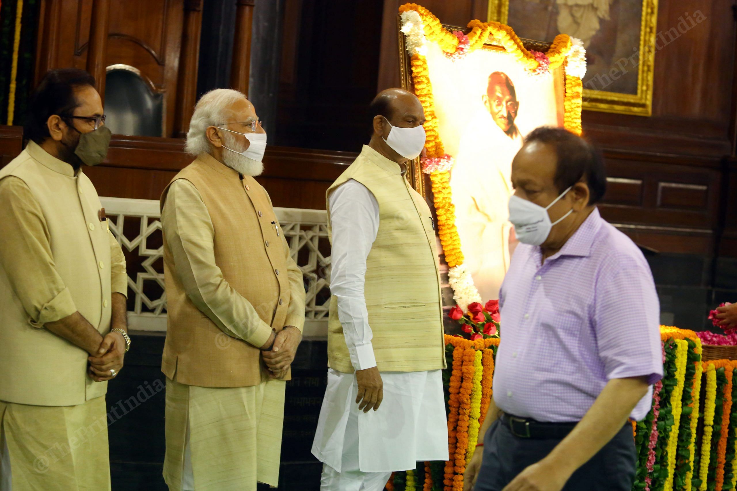 (From left to right) Union Minister Mukhtar Abbas Naqvi, Prime Minister Narendra Modi and Lok sabha speaker Om Birla stand near Gandhi's portrait, as  former Cabinet Minister Harsh Vardhan leaves, after paying tribute to Mahatma Gandhi at Central Hall, Parliament House | Photo: Praveen Jain | ThePrint