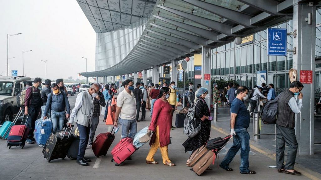 Travellers wearing protective masks arrive at Netaji Subhas Chandra Bose International Airport in Kolkata | Representational image | Photographer: Arco Dato | Bloomberg