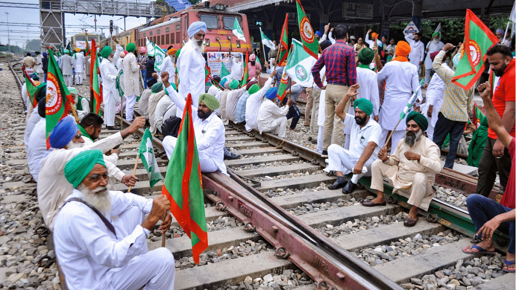 Members of various farmers organizations block railway tracks during a protest against Central government in Patiala, on 18 October 2021.