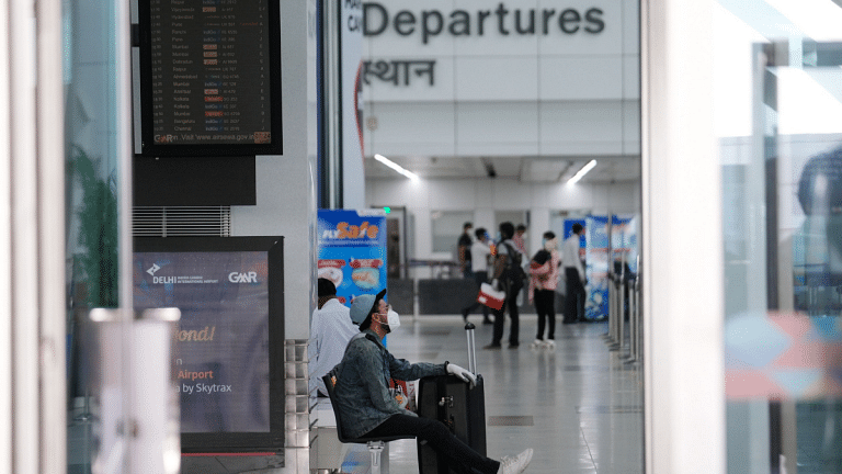 A traveller wearing a mask sits in a departure hall at the Indira Gandhi International Airport in New Delhi | Representational image | T. Narayan | Bloomberg