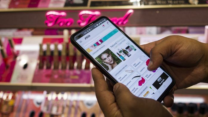 An employee demonstrates the Nykaa application at one of the company's stores in New Delhi| Bloomberg