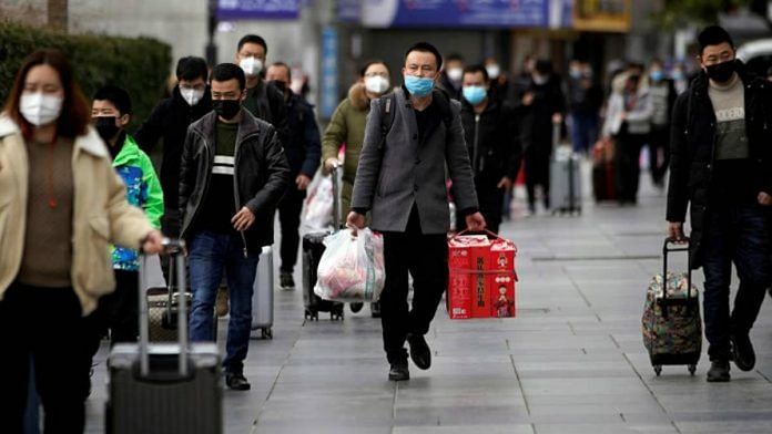 File photo of people in masks outside the Shanghai railway station in China | ANI