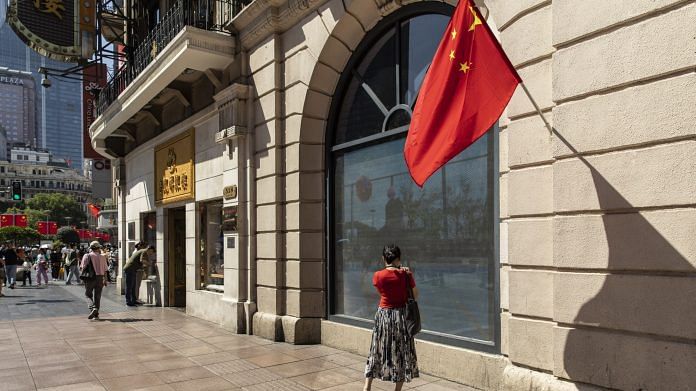 A China flag outside a shop in Nanjing Road East in Shanghai | Photo: Qilai Shen | Bloomberg