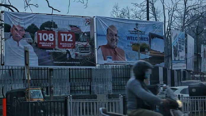 A man rides by a banner welcoming Amit Shah. | Photo: Praveen Jain | ThePrint