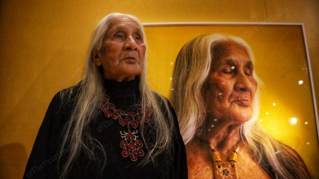 The woman who is known as " Mashi" stands near her portrait at the exhibition | Photo: Manisha Mondal | ThePrint