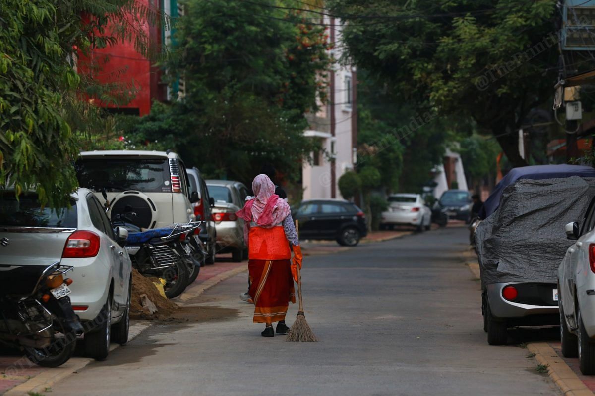 A woman sanitation worker sweeps the residential area in Indore | Photo: Manisha Mondal | ThePrint