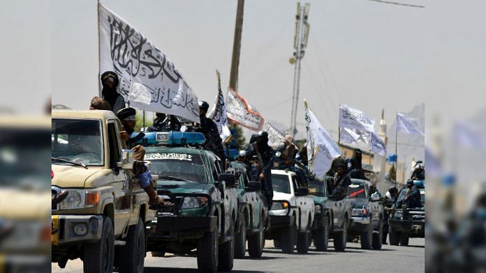 Taliban fighters atop vehicles with Taliban flags parade along a road to celebrate after the US pulled all its troops out of Afghanistan, in Kandahar | Photographer: Javed Tanveer/AFP/Getty Images via Bloomberg