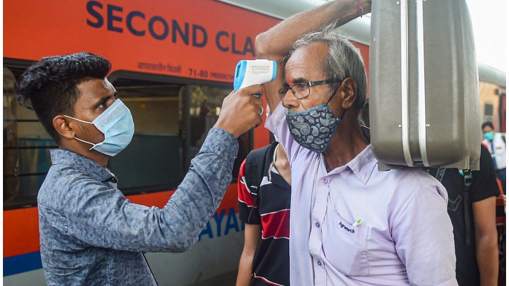 A BMC health worker conducts thermal screening of outstation passengers for Covid-19 testing at Dadar Railway Station in Mumbai on 17 November 2021| PTI