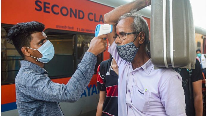 A BMC health worker conducts thermal screening of outstation passengers for Covid-19 testing at Dadar Railway Station in Mumbai on 17 November 2021| PTI