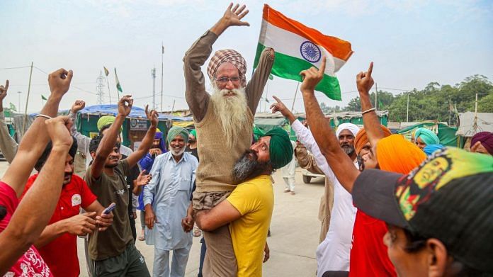 Farmers dance as they celebrate after PM Narendra Modi announced the repealing of the three farm reform laws, at Tikri Border in New Delhi, on 19 November 2021 | PTI
