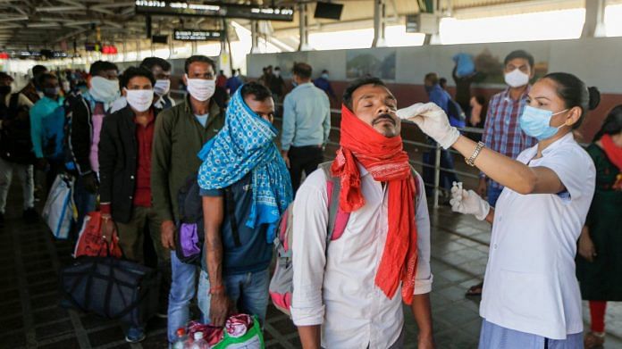 A health worker collects a swab sample of a passenger at Kalupur Railway station in Ahmedabad on 24 November 2021 | PTI