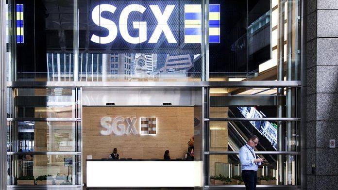 A man checks his phone at the entrance of the Singapore Exchange Ltd. (SGX) headquarters in Singapore | Bloomberg