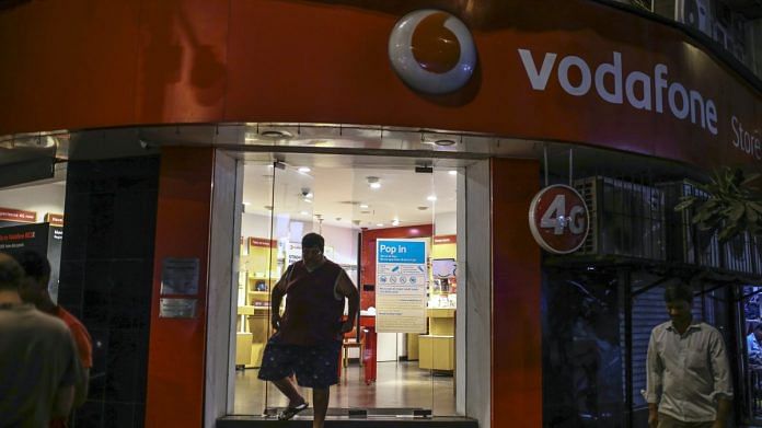 A customer exits a Vodafone Idea store in Mumbai | Photographer: Dhiraj Singh | Bloomberg