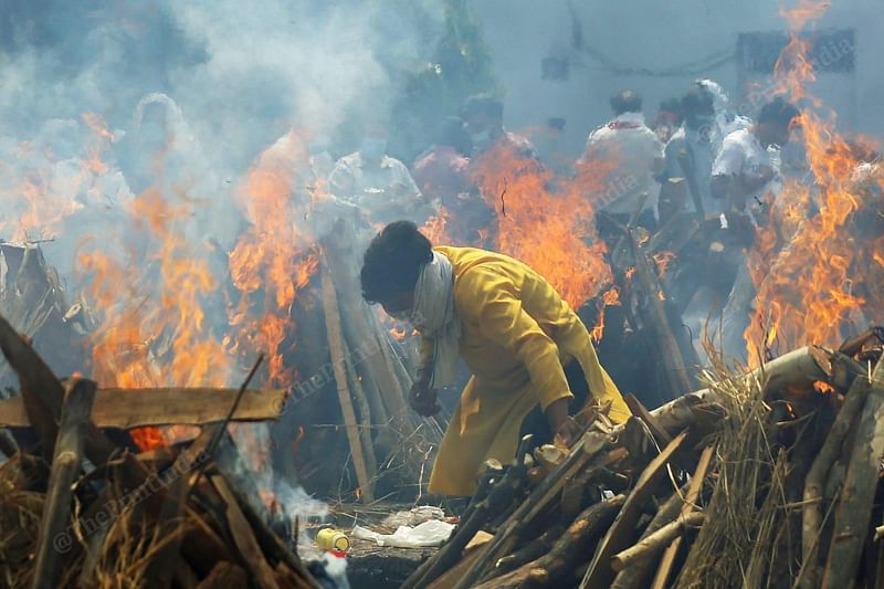 During the second wave of covid, a man burns the pyre at Seemapuri crematorium | Photo: Suraj Singh Bisht | ThePrint