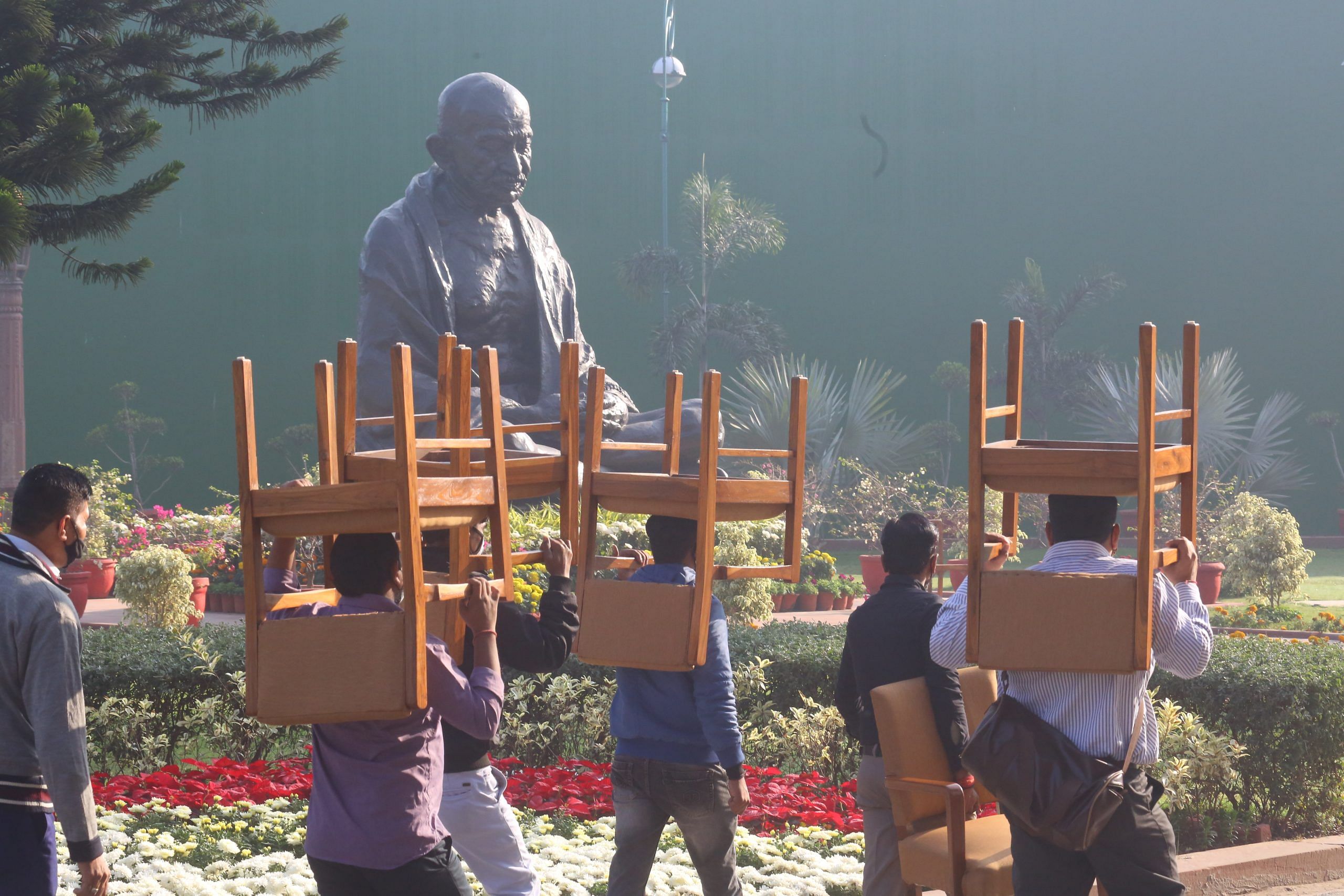 Parliament House staff, carrying chairs, walk by the protest venue | Photo: Praveen Jain | ThePrint
