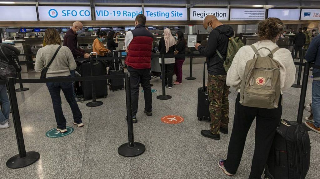 Travelers wait in line to check in at a Covid-19 testing site in the international terminal at San Francisco International Airport, on 2 December 2021 | Bloomberg
