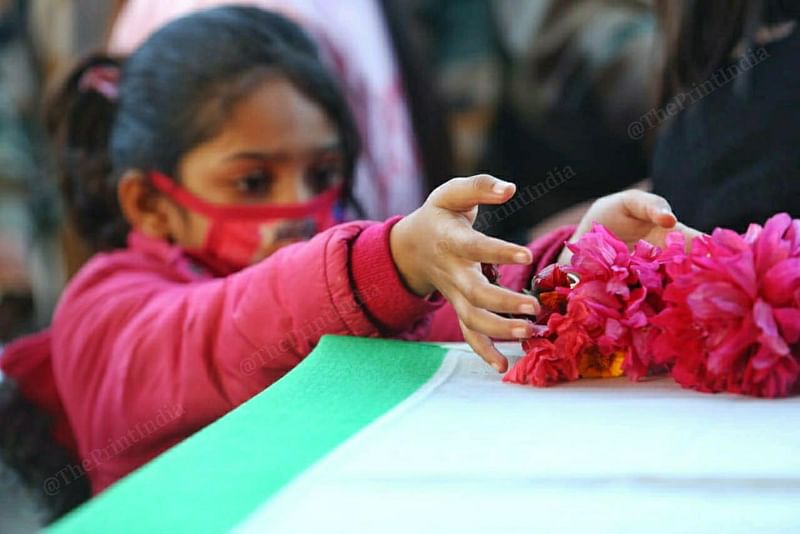 Soldier R.P. Meena’s daughter lays flowers on the coffin carrying his body at Imphal airport Sunday | Photo: Praveen Jain | ThePrint