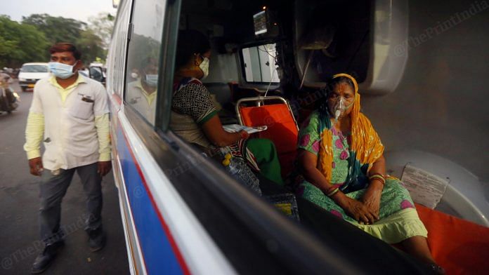 A Covid patient on oxygen support sits in an ambulance in Ahmedabad. During the second wave, hospitals were overcrowded due to the massive rise in cases, leaving several patients waiting endlessly for treatment| Photo: Praveen Jain | ThePrint
