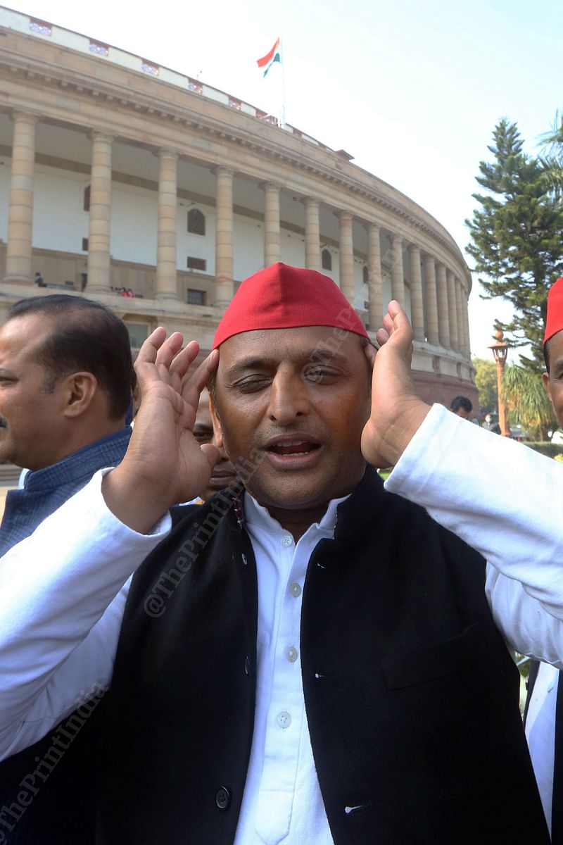 Samajwadi Party president Akhilesh Yadav adjusts his cap as he arrives to support the suspended Rajya Sabha MPs who have been staging a protest near a statue of Mahatma Gandhi in the Parliament complex | Photo: Praveen Jain | ThePrint