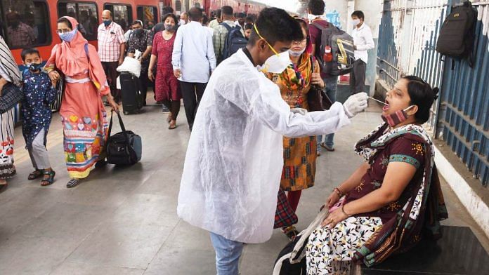 A BMC health worker collects a swab sample of a passenger at Dadar railway station in Mumbai, on 2 December 2021 | ANI photo