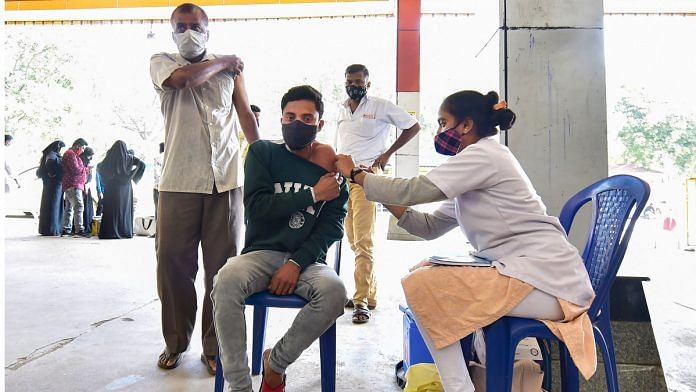 A health worker conducts Covid-19 testing of commuters as Omicron cases cases rise in India, at KSR railway station in Bengaluru on 19 December 2021| PTI