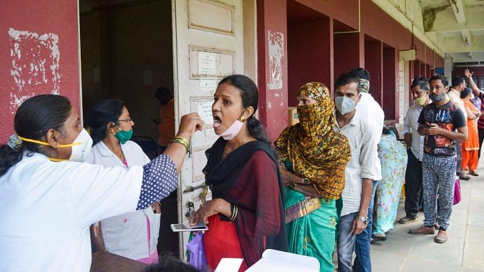 A health worker collects swab samples of a woman for Covid test in Karad, Maharashtra, on 11 December 2021 | PTI